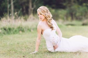 A collage of outdoor wedding portraits featuring a bride in a flowing white gown laying in grass in different poses.