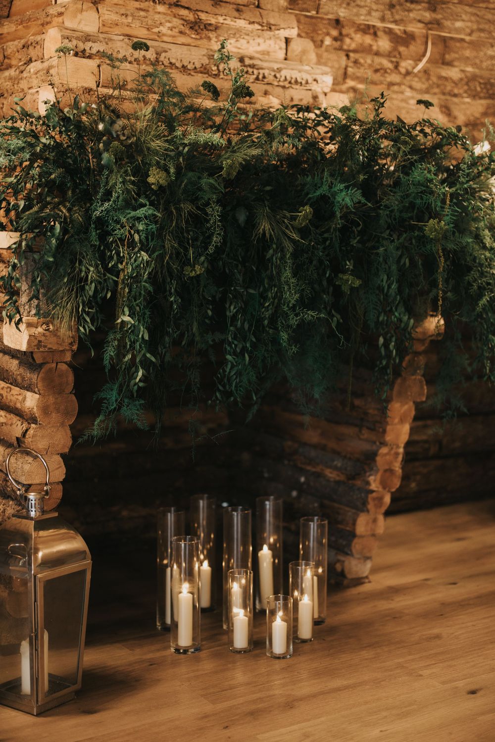 Rustic stone wall wedding venue decorated with elegant candle lanterns and cascading greenery at Grand Lodge Oaklands.