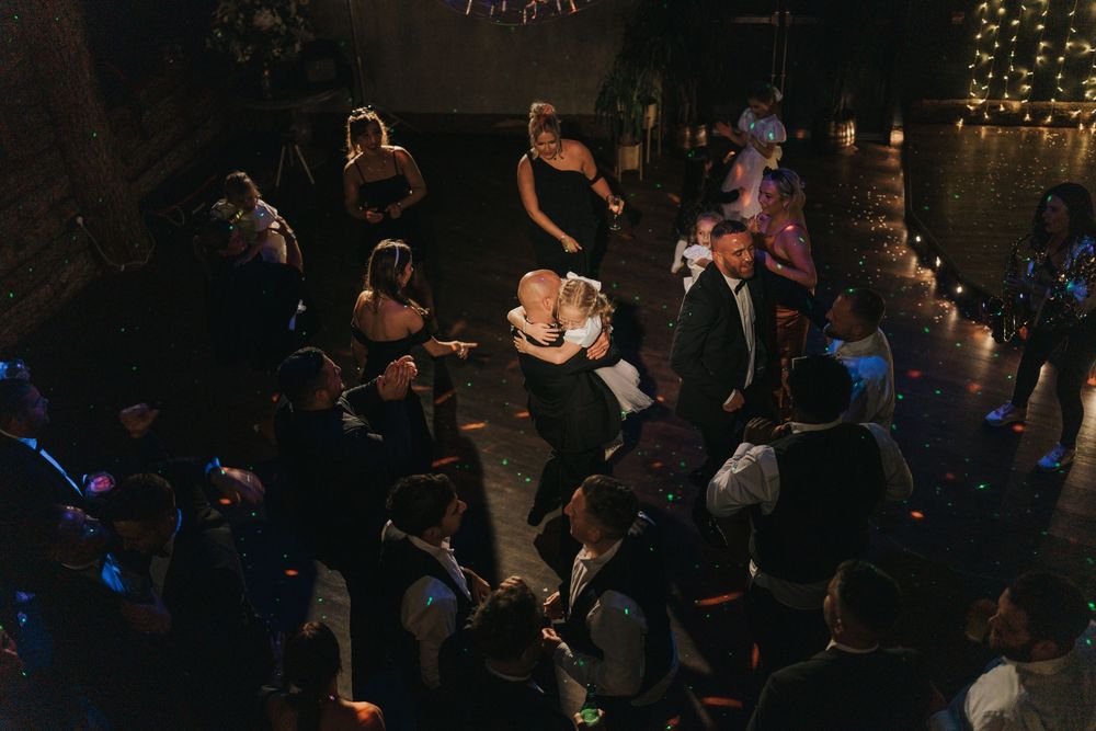 A darkened dining room filled with tables and guests dancing during a wedding at Grand Lodge Oaklands - taken by Grimsby photographer.