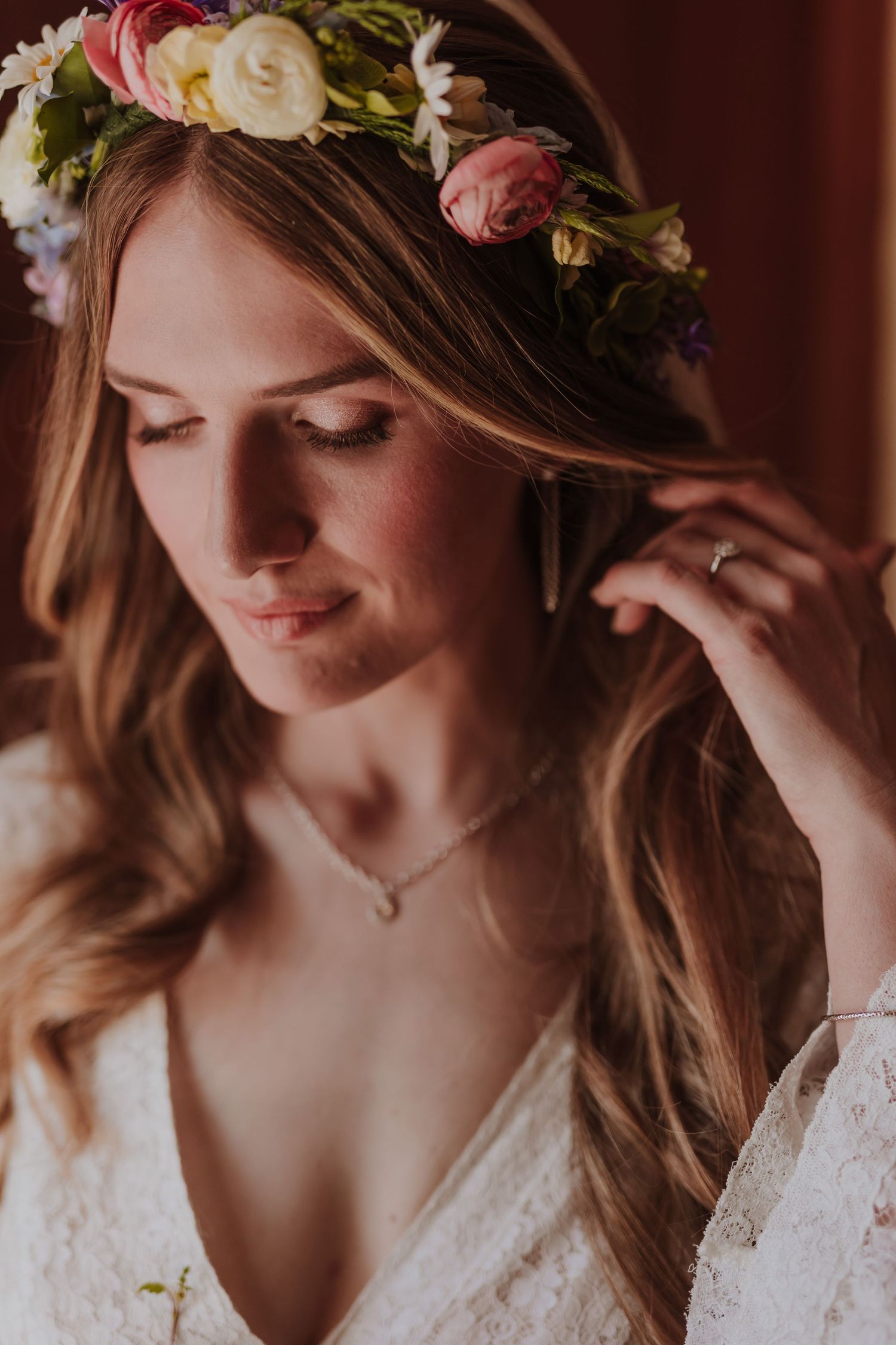 Brie wears delicate flower crown with roses and lace dress details in warm lighting.