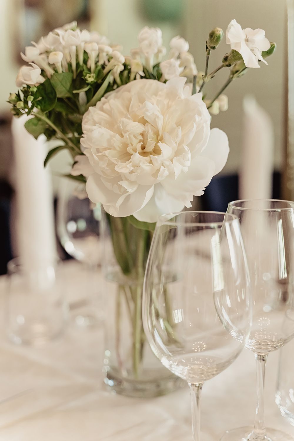 Inspiration bröllopsdukning, vackra vita blommor i vas på bordsdukningen i Vadstena Klosterhotell, fotograf Josefin Landhagen i ÖStergötland