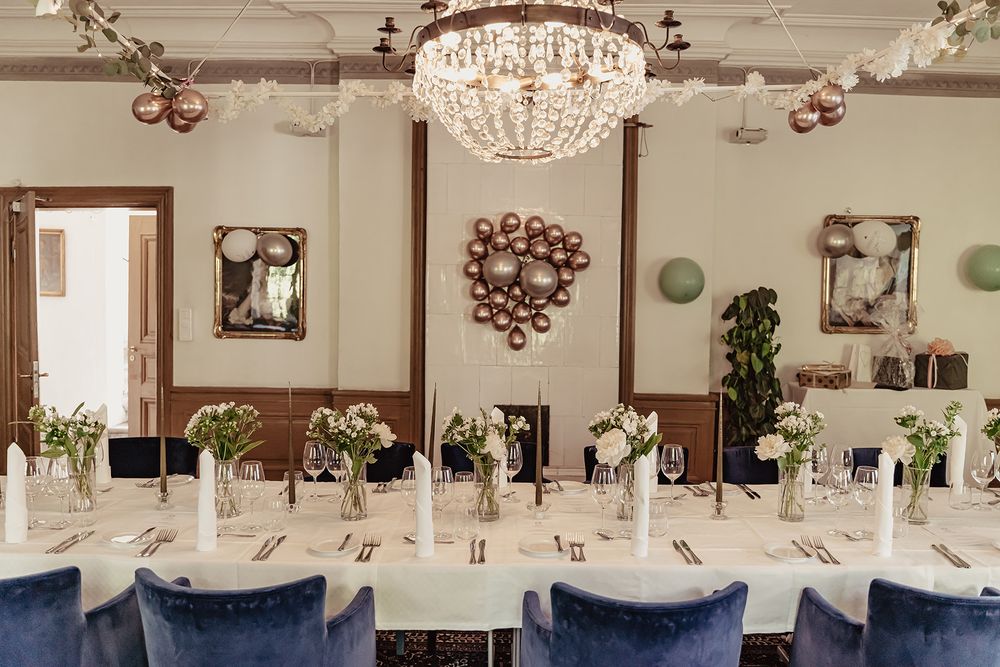 Bröllop på Klosterhotellet i Vadstena, ett långbord är uppdukat i salen med en vacker kristallkrona hängandes över bordet.