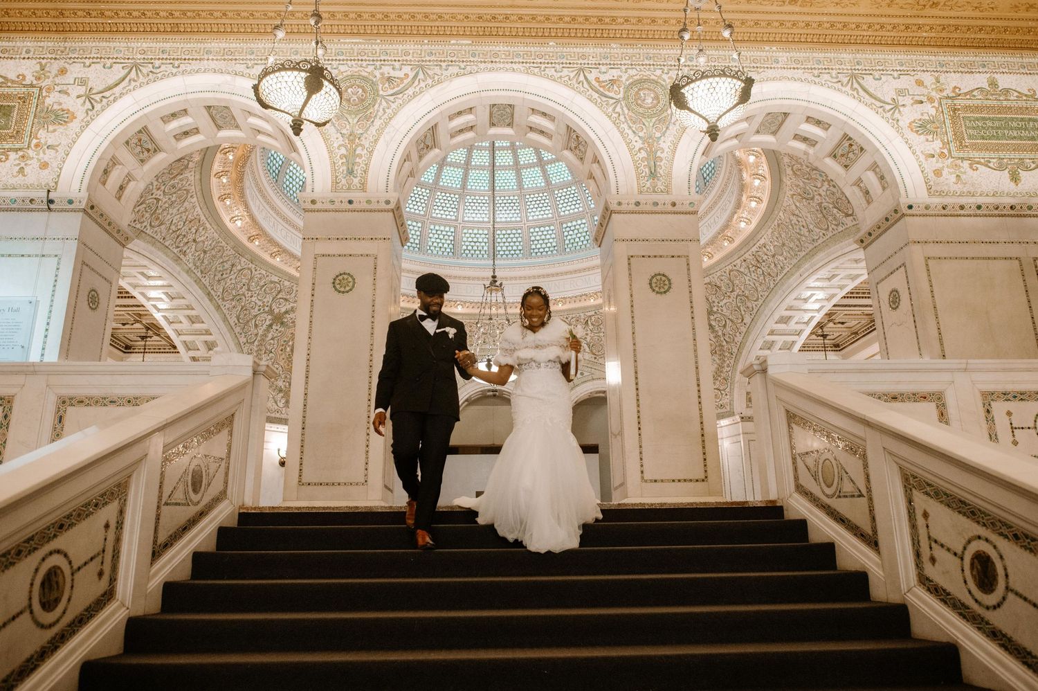 An elegant grand staircase with white marble and ornate architecture features gilded details inside an opulent palace interior.