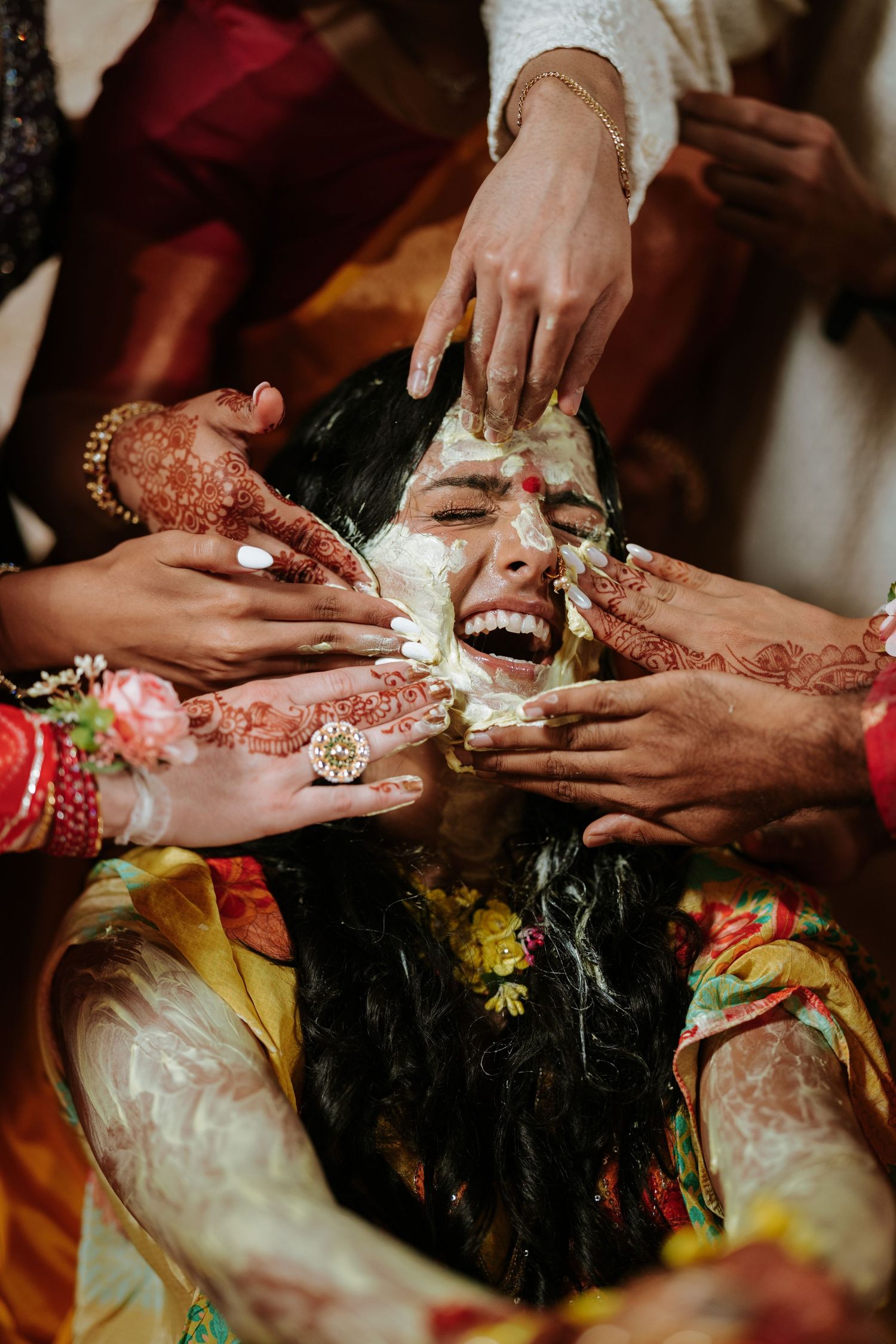 Joyful Haldi ceremony at the Chase Center in Wilmington, Delaware, with the bride covered in turmeric and surrounded by loved ones.