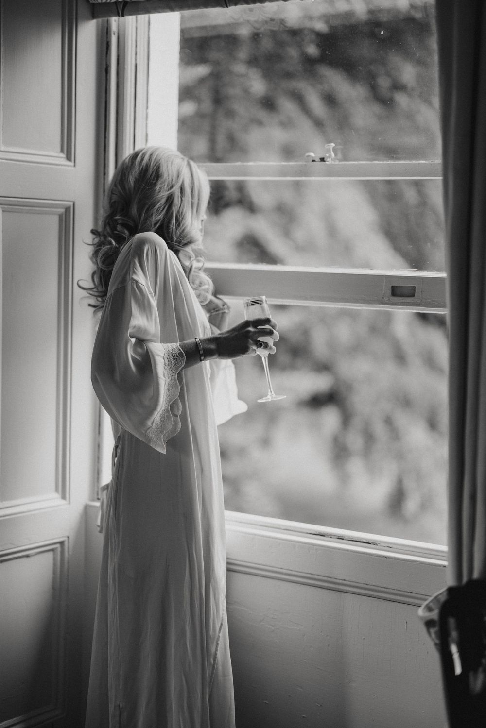 A bride standing by the windows at Cleatham Hall.