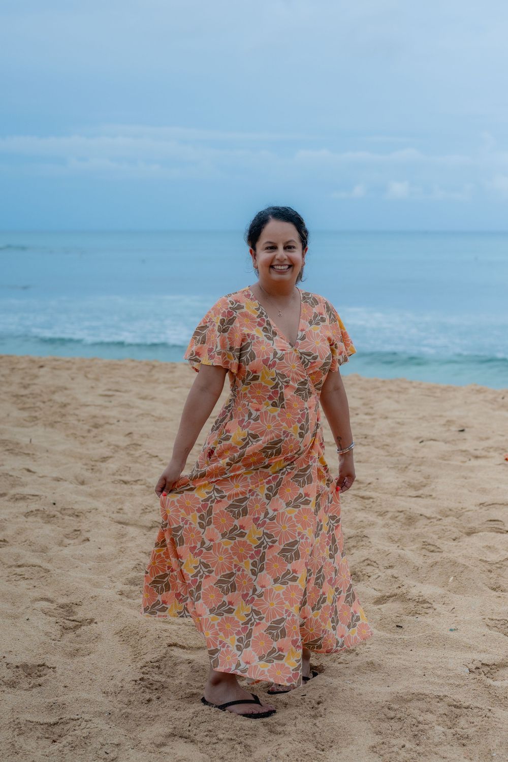 woman in orange dress on waikiki beach walking in sand