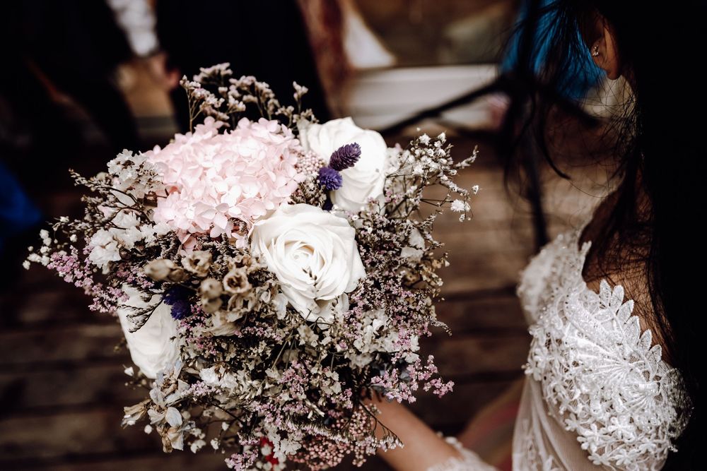 Several baby's breath and floral bouquets on brown wooden surfaces create a soft and delicate wedding decor display.