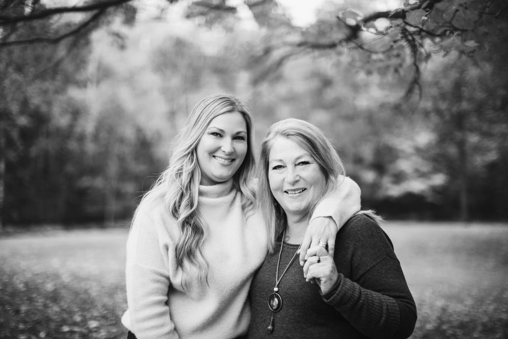 A series of black and white outdoor family portraits showing joyful moments and embraces in a natural setting.