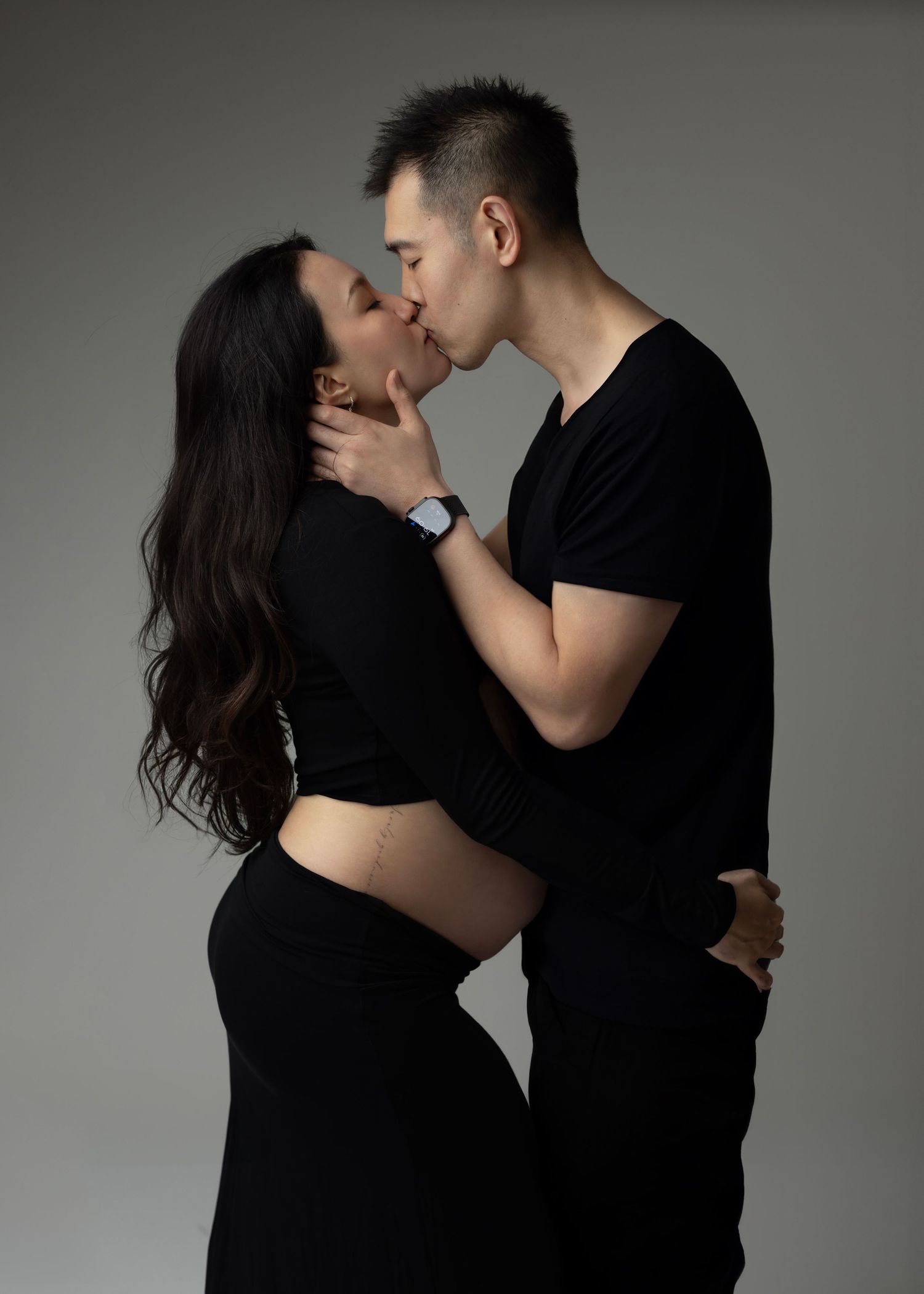 mom and dad kiss in modern clothes. Maternity photos Surrey Vancouver Elizabeth Lang Photography