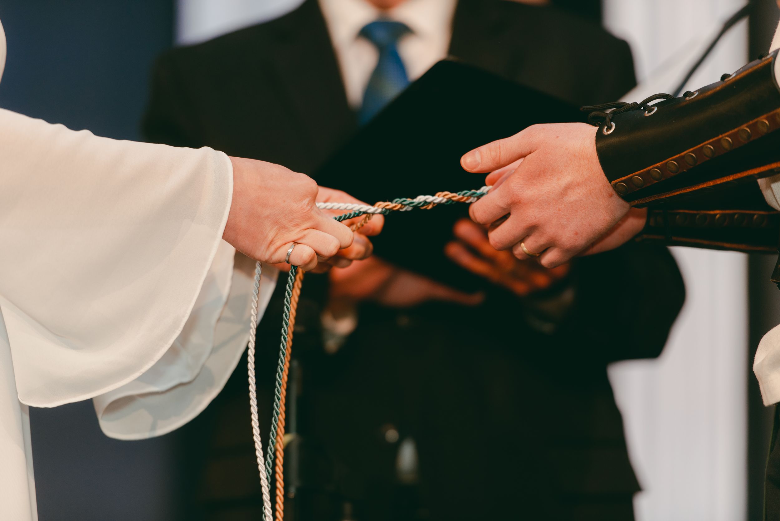 Bride and groom tying the three-stranded cord during ceremony