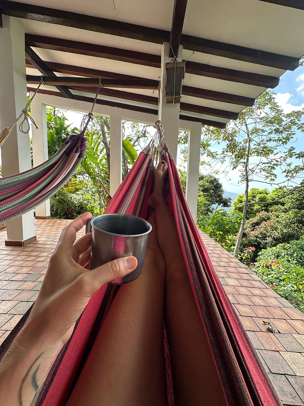 laying relaxed in a hammock with a cup of black coffee