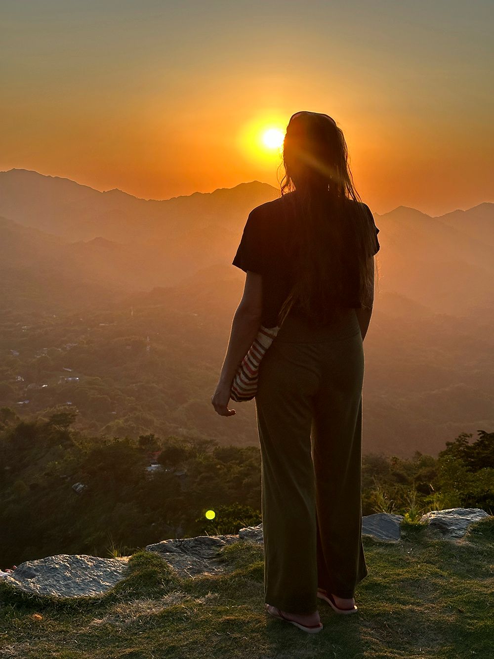 woman looking at the sunset in the mountains