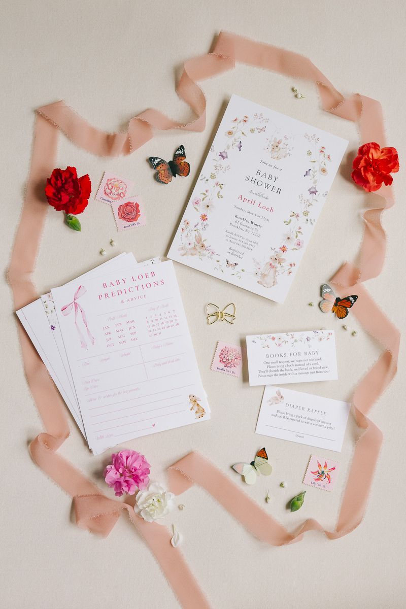 Whimsical baby shower invite featuring delicate flowers and butterflies, beautifully styled by NYC baby shower photographer Paula Brearley.