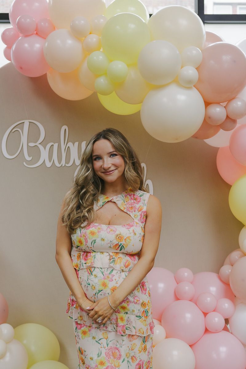 Elegant maternity portrait of a mom-to-be surrounded by lush balloon arrangements, taken at a Brooklyn baby shower by Paula Brearley.