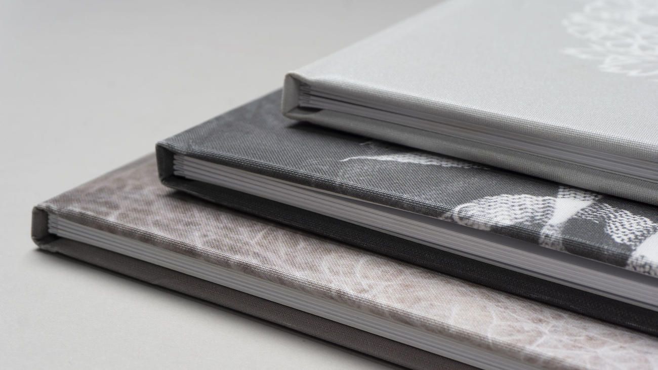 Close-up view of stack of grayscale hardcover album spines with minimalist design patterns.