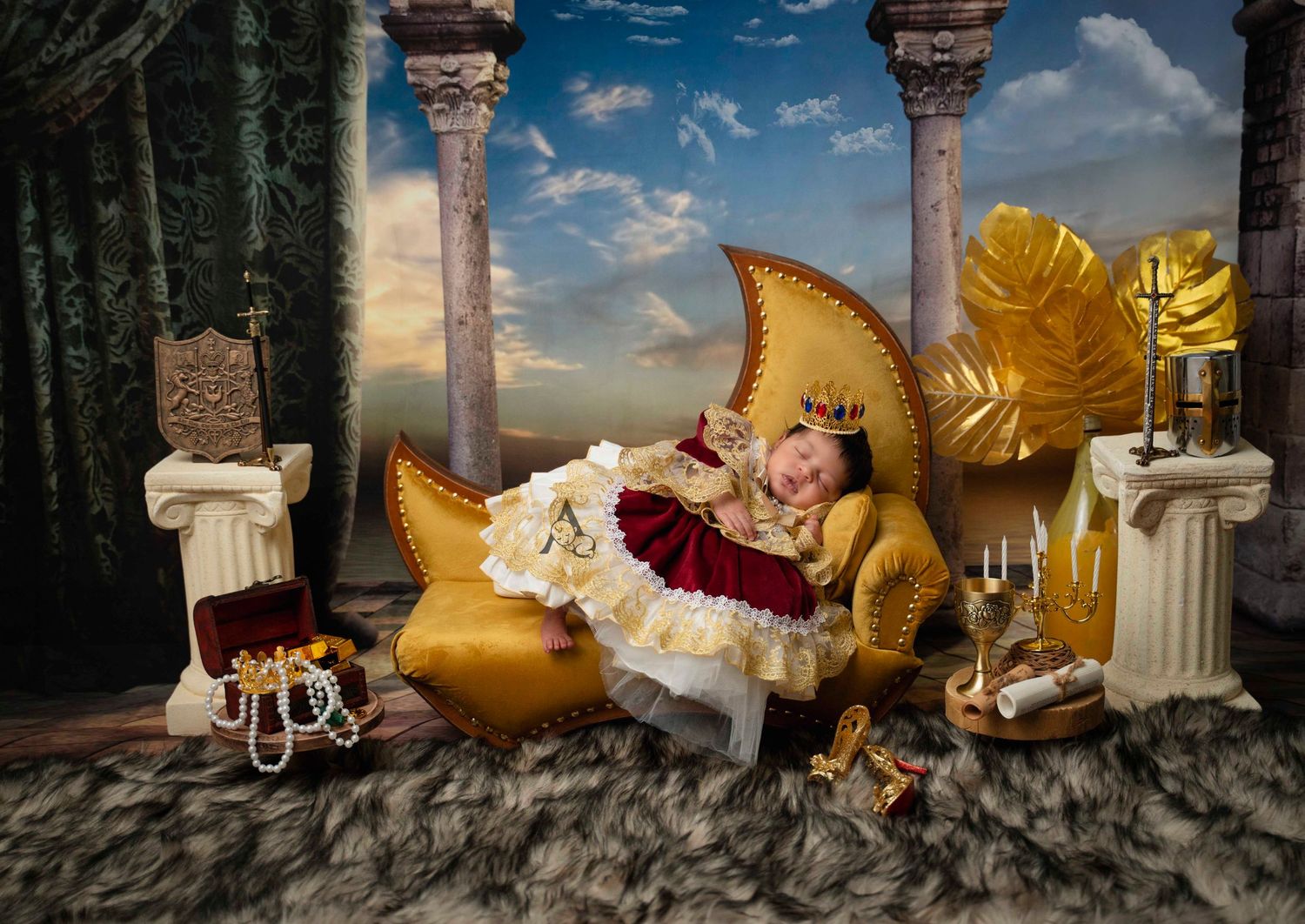 Fantasy newborn portrait with golden moon prop and classical columns in an outdoor temple setting.