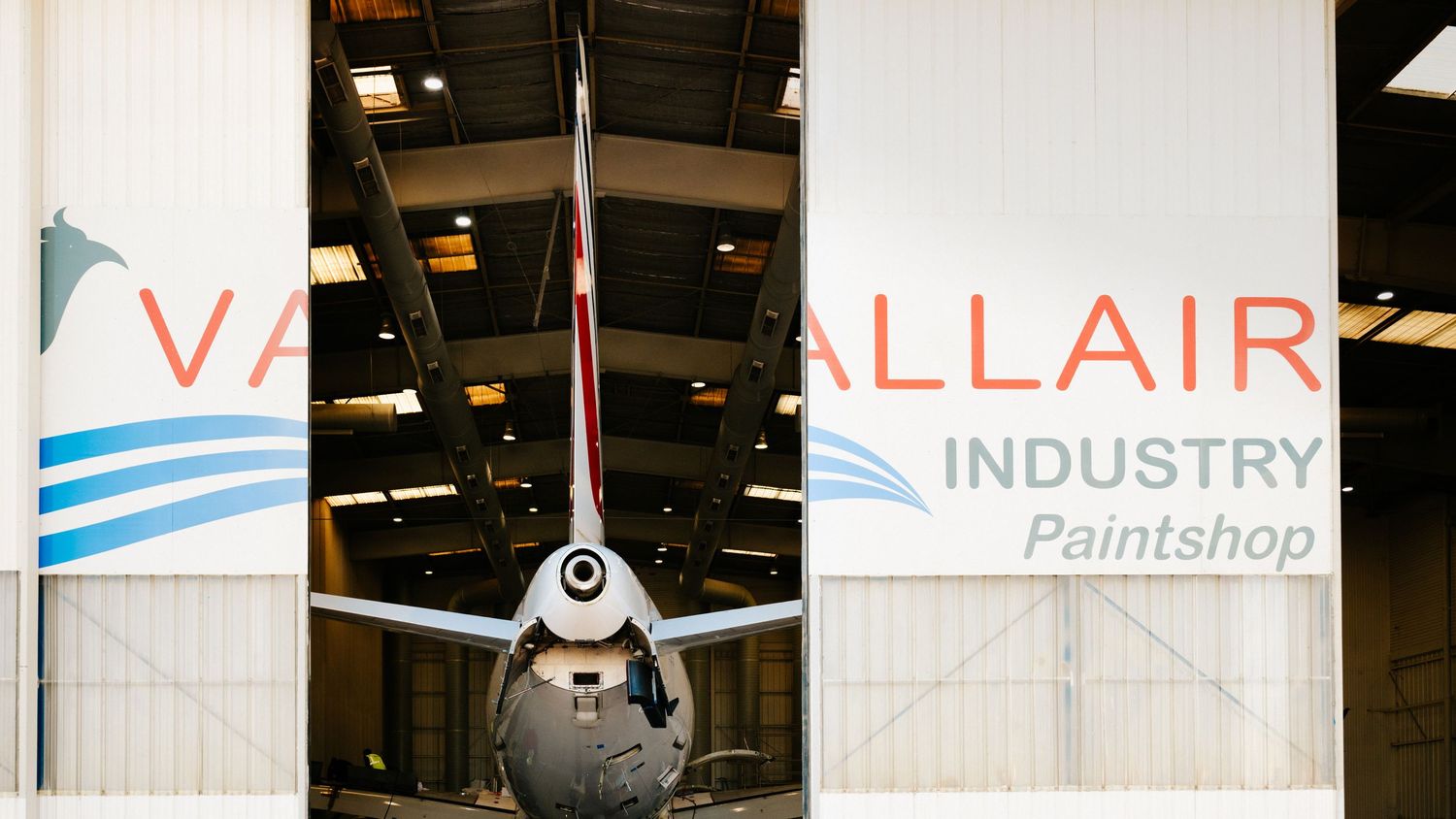 Photographe professionnel : Reportage industriel. Queue d'avion dans un hangar de maintenance avec signalisation Vallair Industrie.