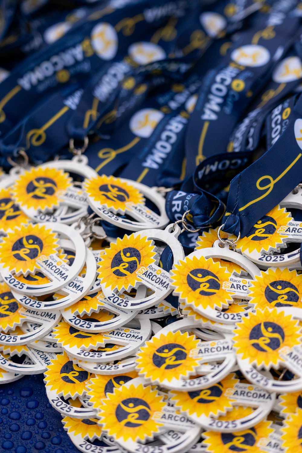 Collection of circular yellow and white medals or badges with ARCGMA branding displayed on dark blue fabric background.