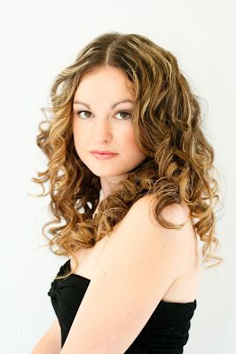 Studio portrait featuring natural curly hair and black strapless top.