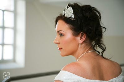 Side profile portrait showcasing elegant bridal hairstyle and off-shoulder gown.
