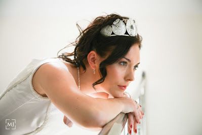 Dreamy side profile of bride wearing white crown and dress.
