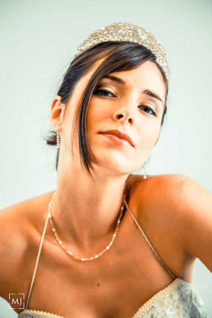 Elegant bridal portrait featuring a pearl crown headpiece and delicate necklace.