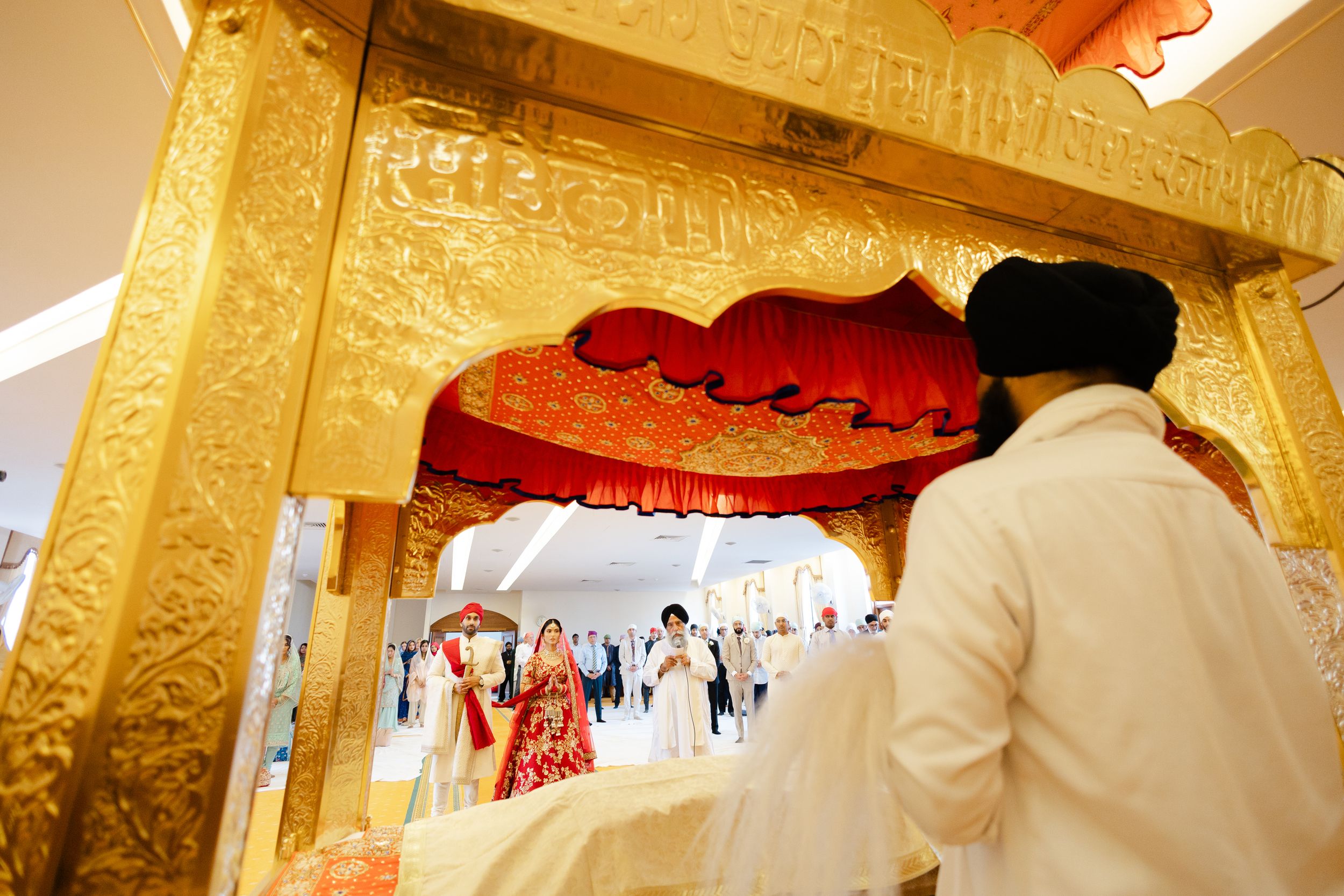 Sikh Indian bride and groom standing during their ceremony in Hounslow Gurdwara
