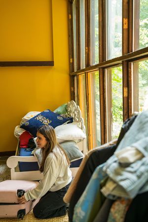 Sunlit interior room with yellow walls and cushioned seating visible through windows.