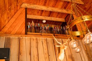 Rustic wooden loft space with collection of tools and hanging light fixtures.