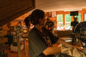 Person working in a dimly lit rustic cabin space with warm lighting.
