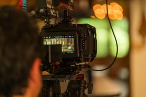 Professional video camera equipment setup with soft lighting in dimly lit environment.