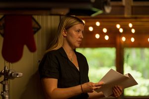 Film crew members reviewing documents in a warmly lit indoor space.
