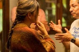 Two people having an animated conversation in casual setting with natural lighting.