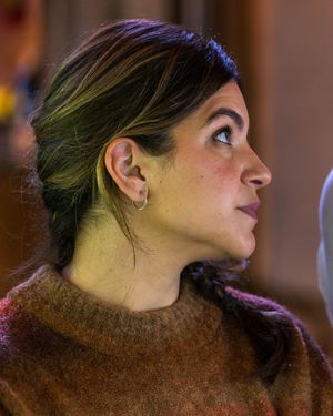 Profile view showing multiple expressions in warm lighting wearing a brown textured sweater.