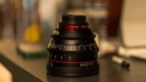 Close-up of camera lenses arranged in a row on a dark surface.
