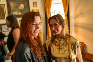 Two friends sharing a moment in a warmly lit room with vintage decorative elements.