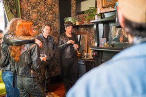 A group of people gathered in a cozy indoor setting with rustic decor and warm lighting.