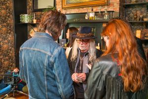 People gathered in dim lighting at a cozy bar with vintage decor and ambient atmosphere.