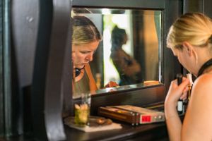Two people interact through a window opening during a film production.