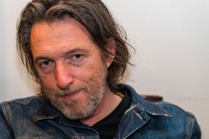 Portrait session with subject wearing a denim jacket against a white backdrop.