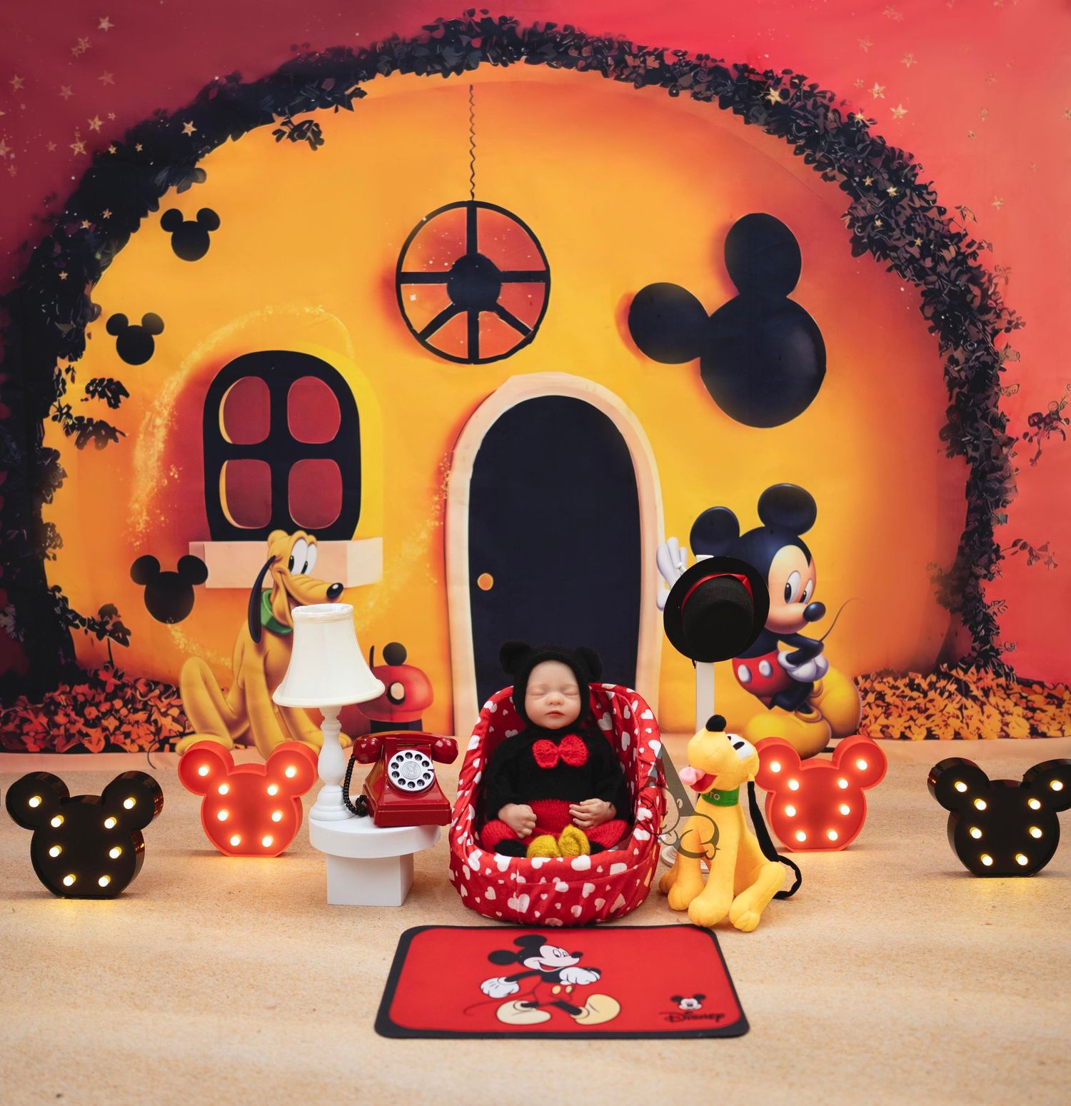 Mickey Mouse themed room decor with orange sunset backdrop and character figurines.
