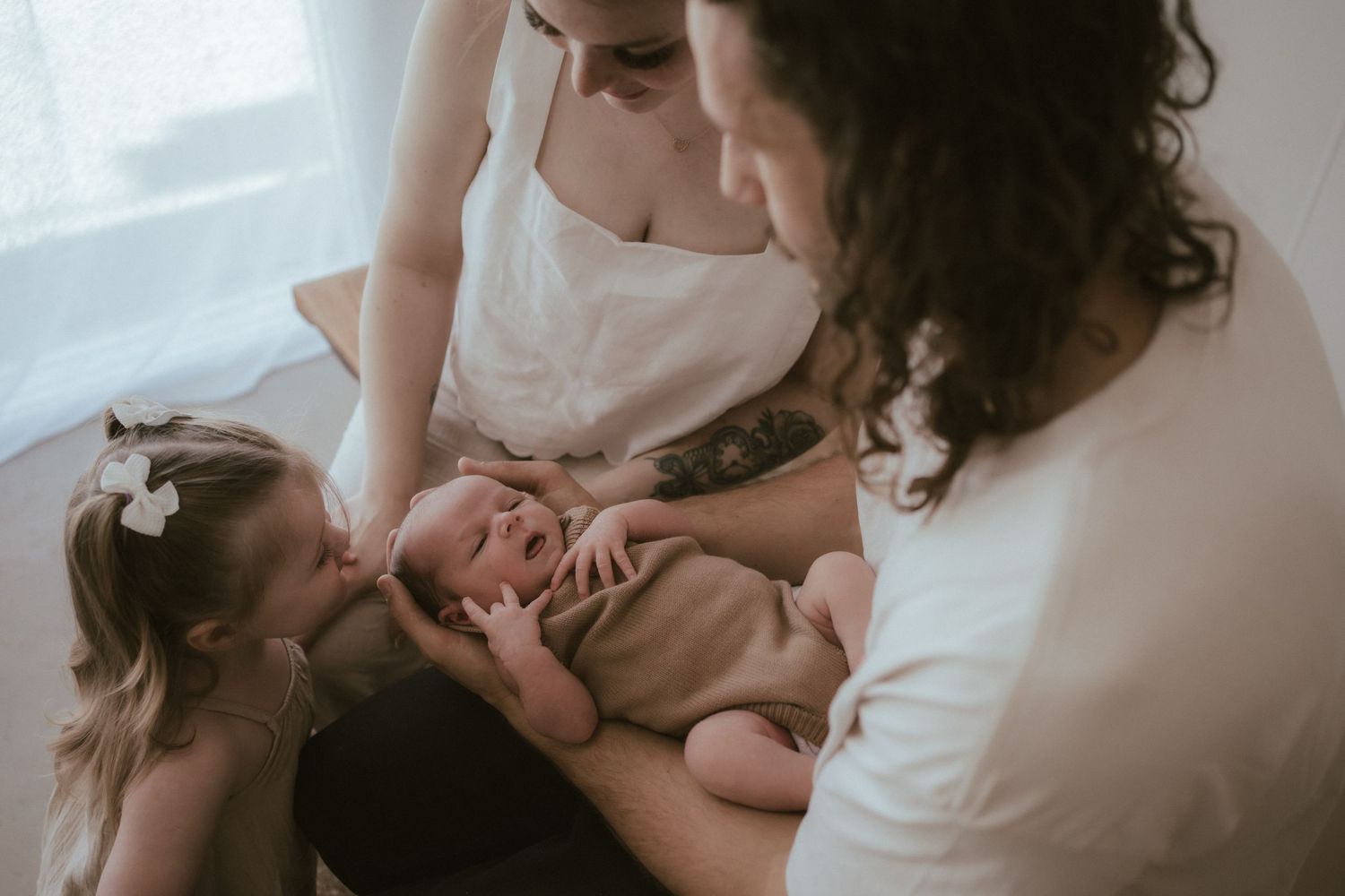 A toddler and newborn being lovingly embraced together in an intimate moment in Healesville Studio