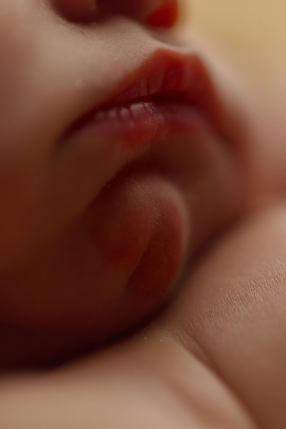Close-up macro photograph of red lips with soft focus and warm tones.