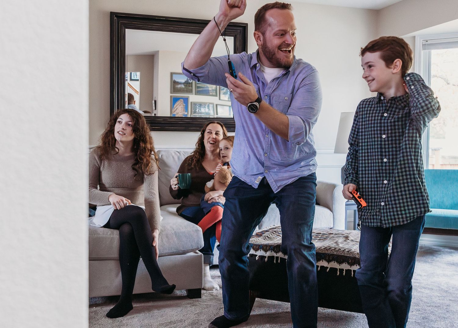 People enjoying play time together in a bright living room with a sofa and turquoise decorative accents.