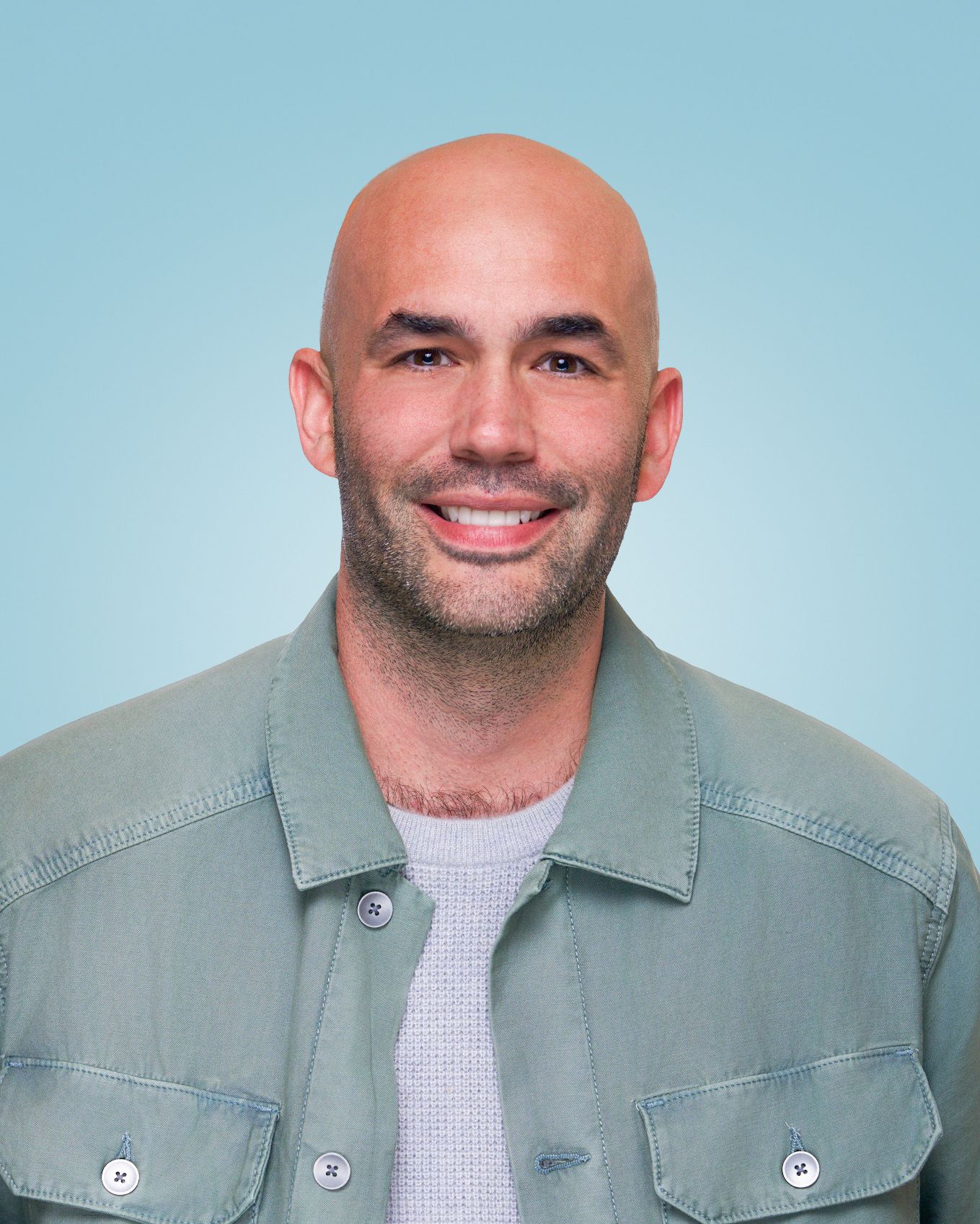 Portrait of person in denim jacket against light blue background.