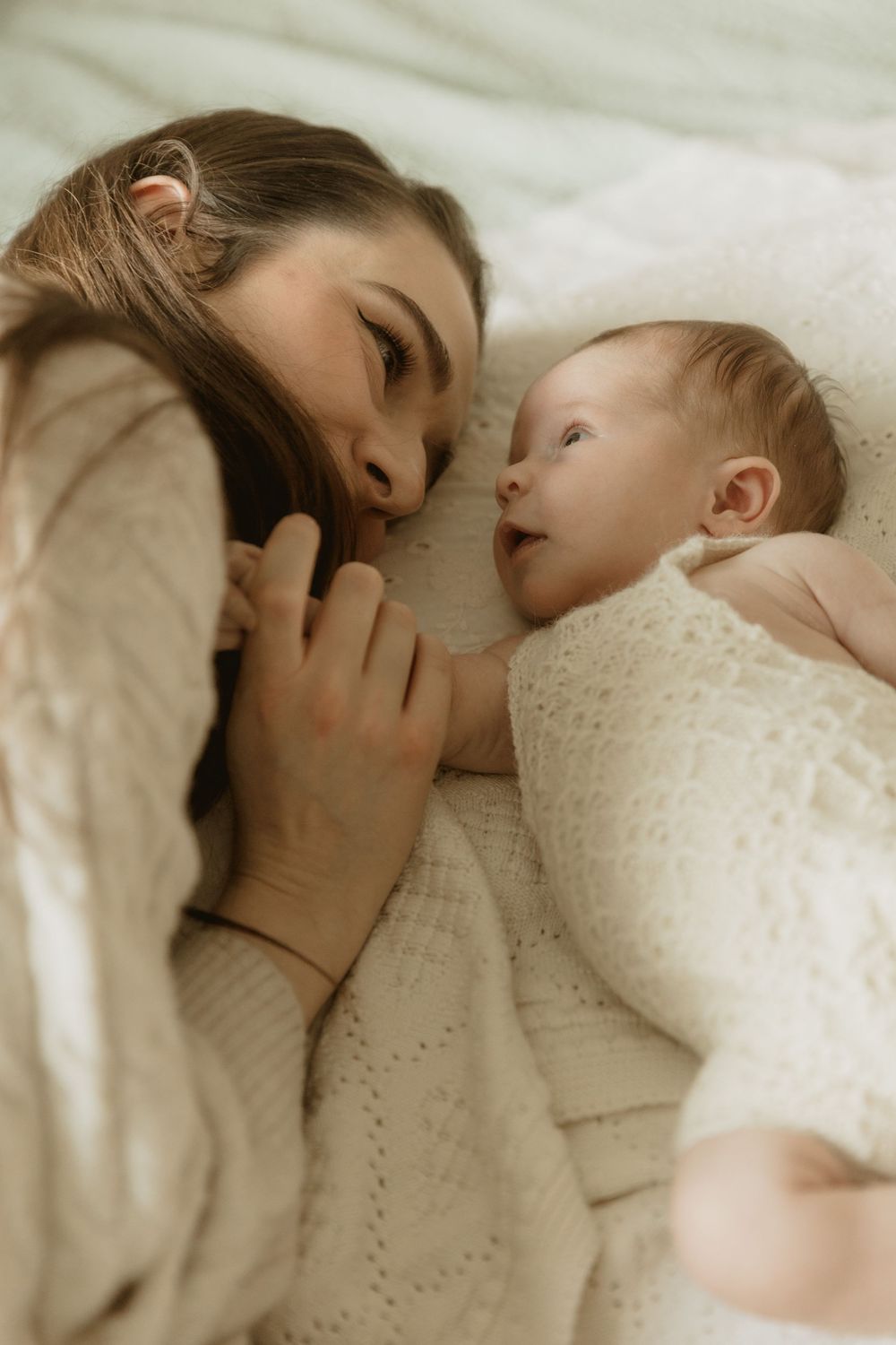 A tender moment captured in warm tones as parent and child share a peaceful embrace while resting together.