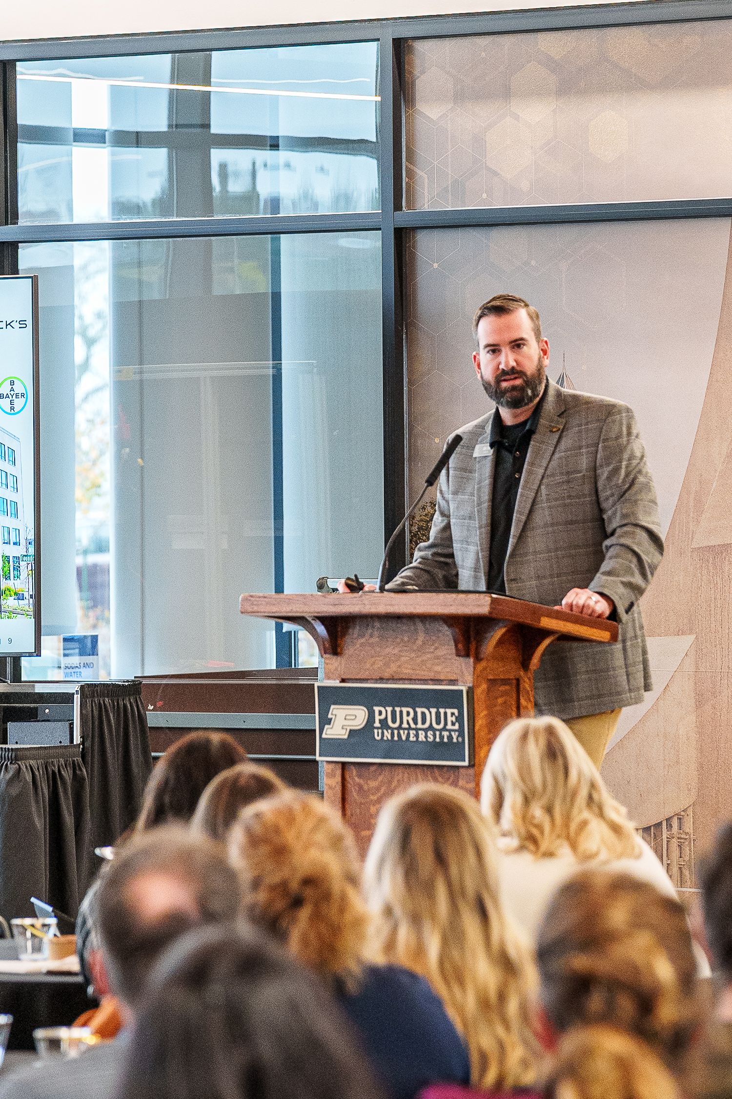 Speaker delivers presentation at podium during event at Purdue University conference center.