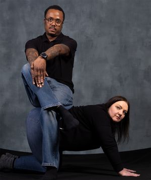 Creative studio portrait with dynamic poses showing a couple in black clothing.