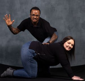 Fun studio portrait capturing dynamic movement and interaction between two people.