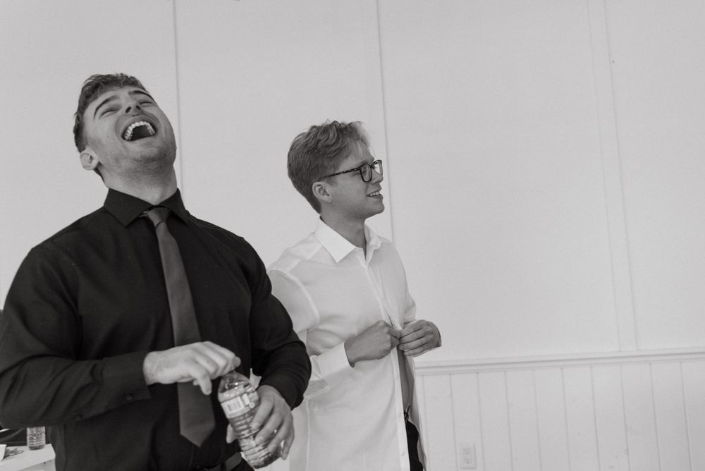Two people sharing a candid laughing moment together in black and white photography.